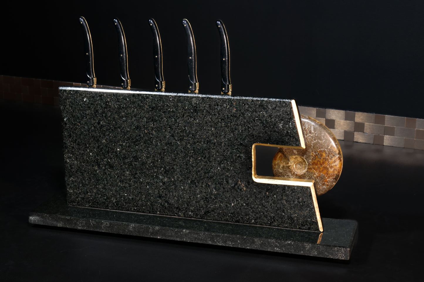 Knife block made of Nero Impala with gold plating and an ammonite